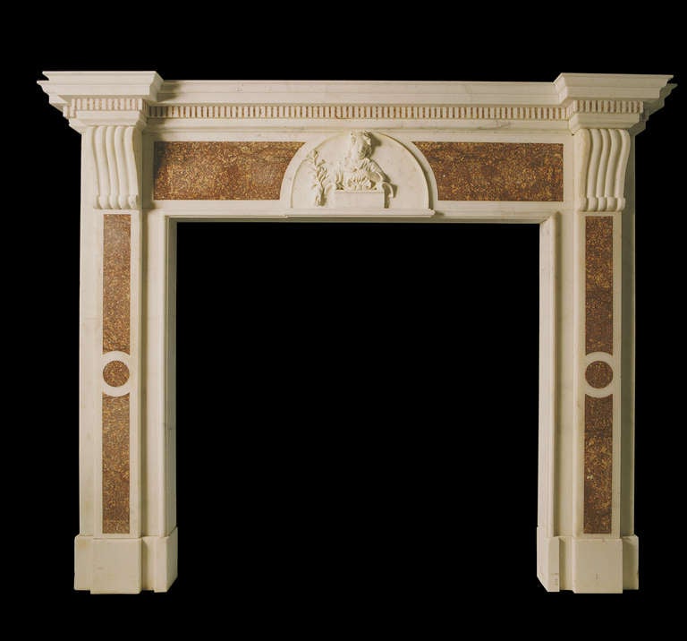 Late 18th century mantel in statuary marble with Spanish Brocatella inlaid panels to the frieze and jamb, the latter terminating beneath simple moulded corbels and the former flanking a robustly carved central frieze panel depicting a child. Please