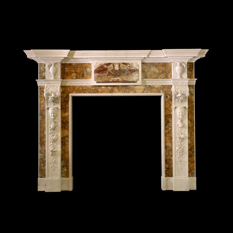 A magnificent mid-18th century mantel in statuary marble with heavily carved foliate pilasters headed by masks beneath carved trussed which support corner blockings carved with ewers. Opening dimensions: 43.75