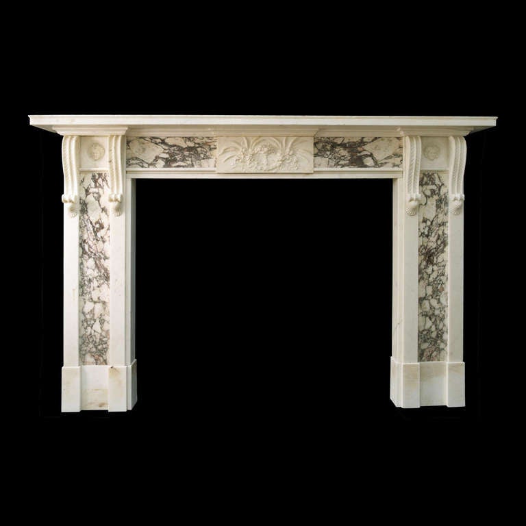 An important early 19th Century mantel in the style of Henry Holland in Statuary marble with panels of Breche marble to the jambs bordered by plain raised Statuary panels terminating in delicately carved twin corbels flanking panels inset with