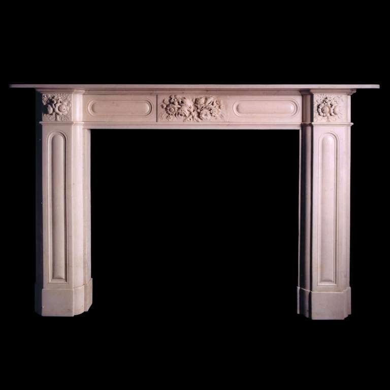 A handsome Regency mantel in Statuary marble with oval cushion moulded panels to the jambs and frieze, the latter flanking a center tablet finely carved with a bouquet of flowers and corner blocks carved with ribbon tied sprays of flowers. Opening