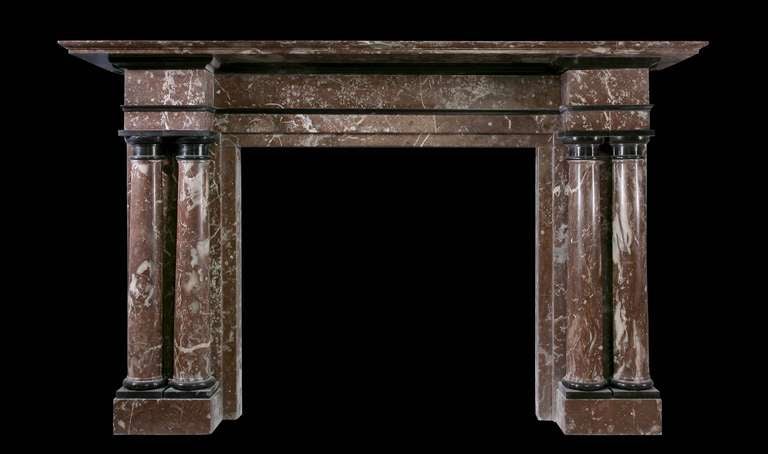 An impressive late 19th century mantel of architectural form in Breche marble embellished with polished slate mouldings, the jambs with engaged twin columns of Doric form terminating beneath plain capitals and frieze incorporating a horizontal slate