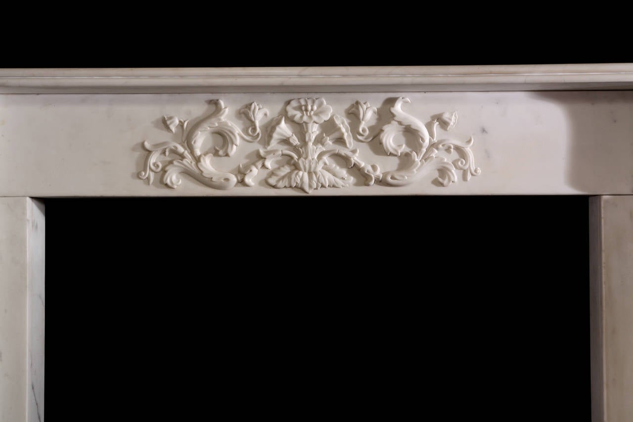 A very good William IV mantel in statuary marble with inversely tapering pilasters carved with rod and pineapple finial, the symbol of wealth and welcome, decorated with vines and terminating beneath acanthus corner blocks, the frieze crisply carved