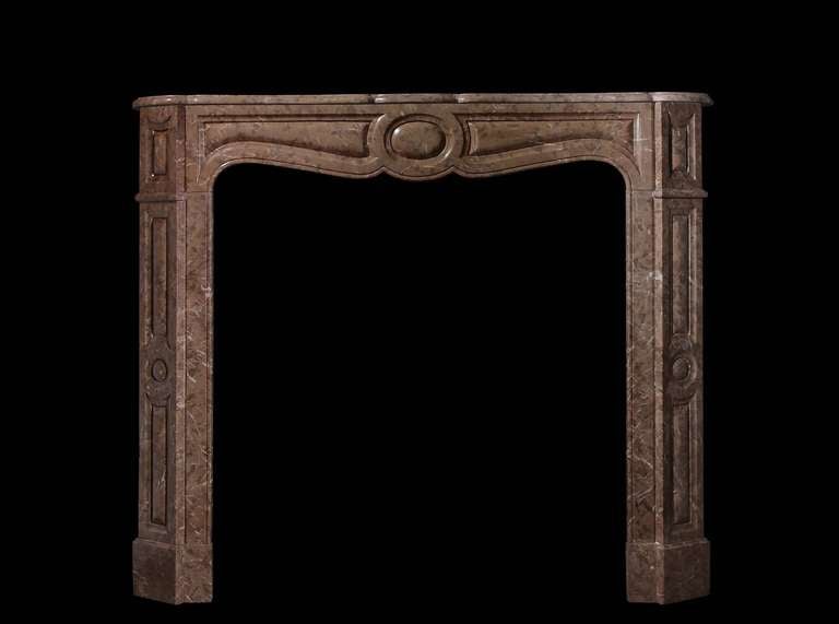 A 19th century Pompadour style chimneypiece in a rare Loudes Coquina marble. 
Opening dimensions: 33.75