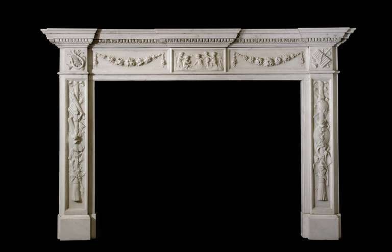 Impressive Italianate mantel in statuary marble with heavy carving of musical instruments to the jambs and corner blocks. The frieze panels feature carved floral swags flanking a tablet of carved cherubs. Opening dimensions: 51.75