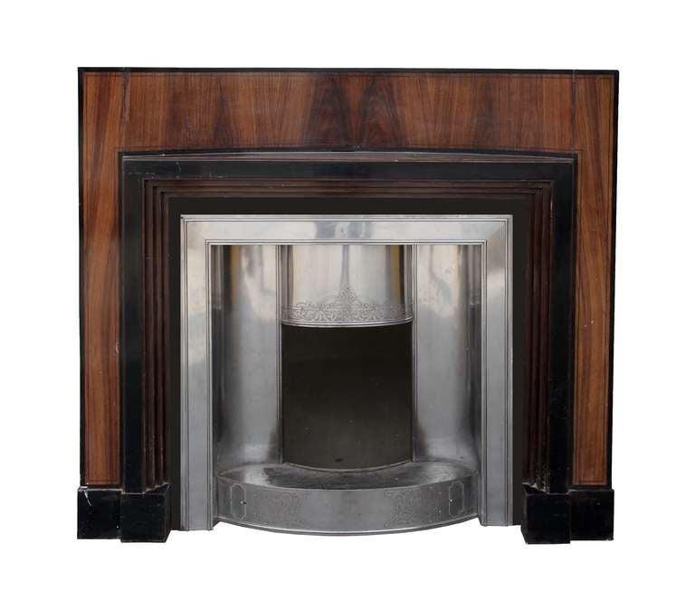 A very interesting Art Deco mantel with different dark woods with its original circa 1920 polished steel decorative insert. Opening dimensions: 41.5
