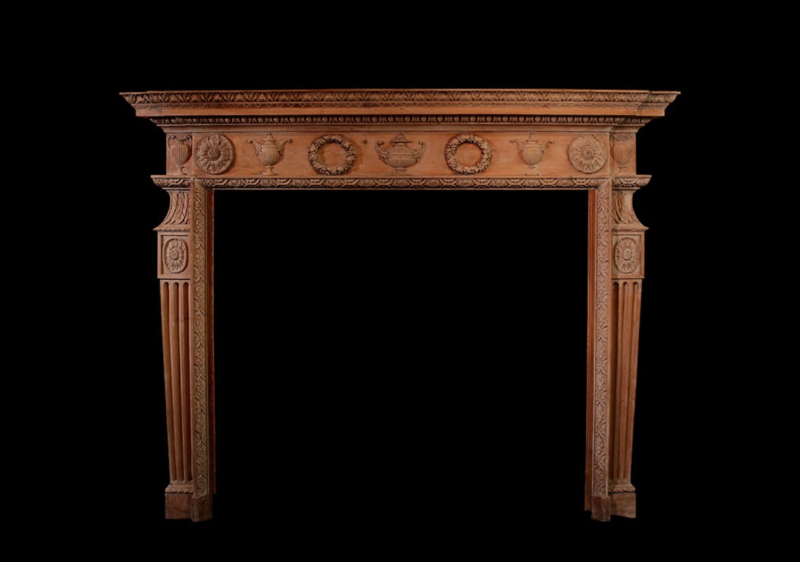 An exquisitely well carved English pine mantel of robust neoclassical form, featuring a running frieze of garlands of fruiting vines, circular rosettes and classical urns all carved in deep relief.
Opening dimension: 51 1/4