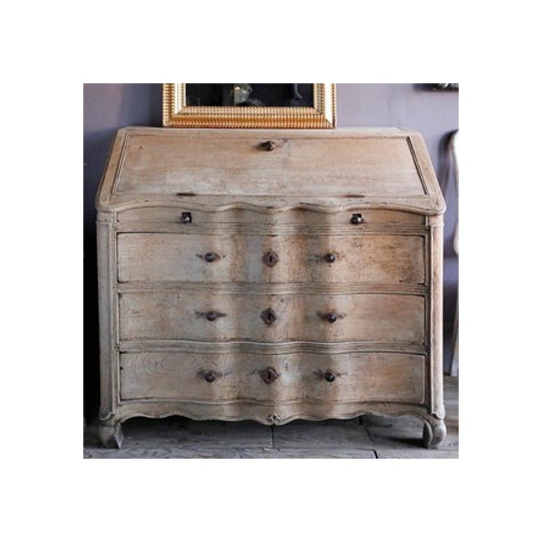 A gorgeous French secretary or chest with a slant front in solid bleached oak and a shapely double curved facade. The interior has numerous drawers including a secret lower area, circa 1780.