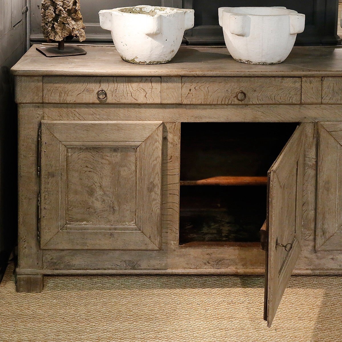 A French buffet or enfilade from the 19th century in bleached oak with original hardware.  This beautifully rustic piece has three drawers above three doors.that open to an interior shelf.