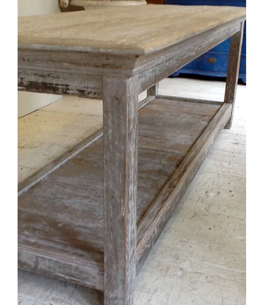 A large 19th century French antique pine drapers table with pot board in an aged old white patina. This table would make a stunning kitchen island, console, or serving table.