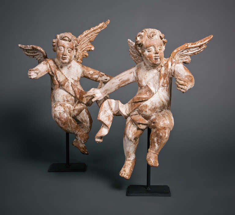 Our 18th century Italian wooden cherubs are mounted on new iron bases. The cherubs were once gilded. Now, stripped of the gild and bole to reveal the natural wood and creamy white gesso. They would make a wonderful display.

These angelic figures