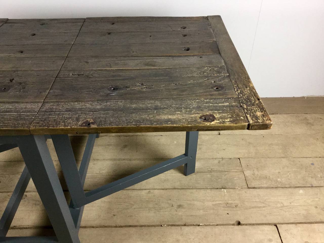 A rustic, English drop leaf table with a 19th century reclaimed, solid elm top on a new base. This table has a beautiful patina and would seat six comfortably.