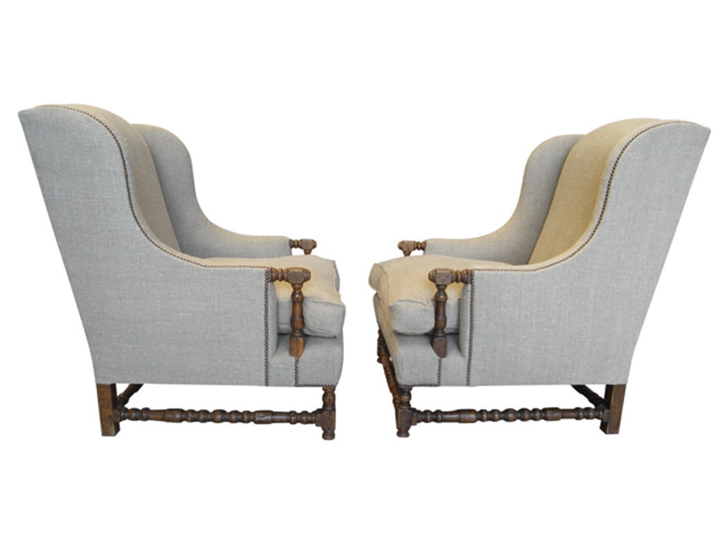 An impressive pair of French oak wingback bergere chairs newly upholstered in hemp linen.