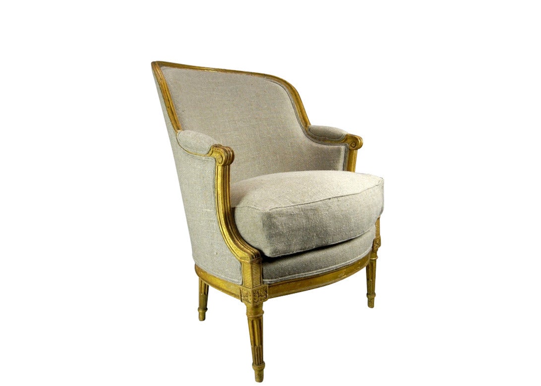 A stunning French parcel-gilt, barrel back bergere in the Louis XVI style, newly upholstered in European hemp linen.