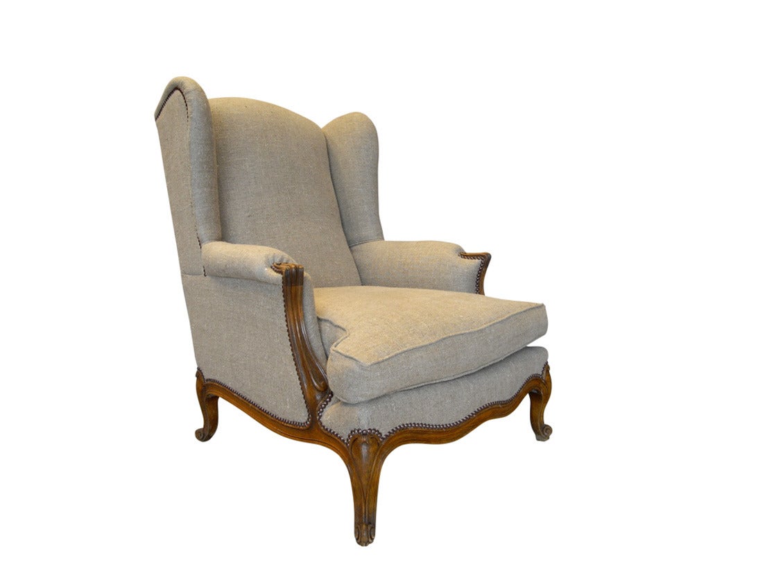 A very fine late 19th century French Louis XV style wingback bergere made from walnut and newly upholstered in hemp linen.