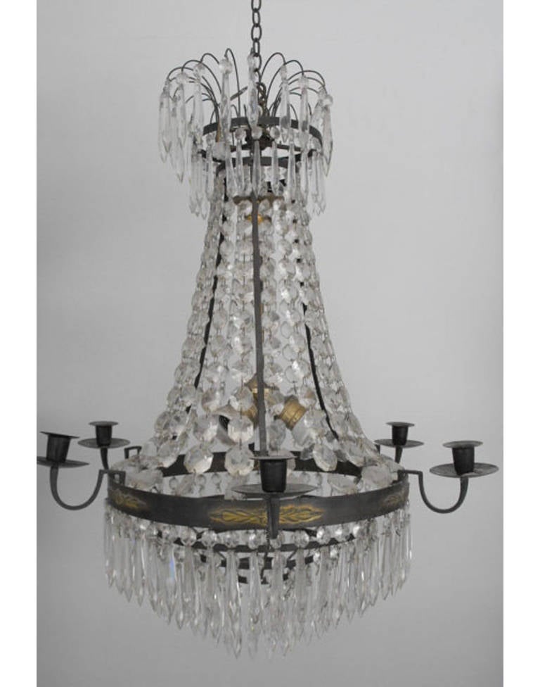 A graceful early 20th century Swedish crystal chandelier in the Gustavian style.  The original frame has nicely oxidized over the years.  This chandelier has been newly wired for European electrical current and three bulbs have been added to the
