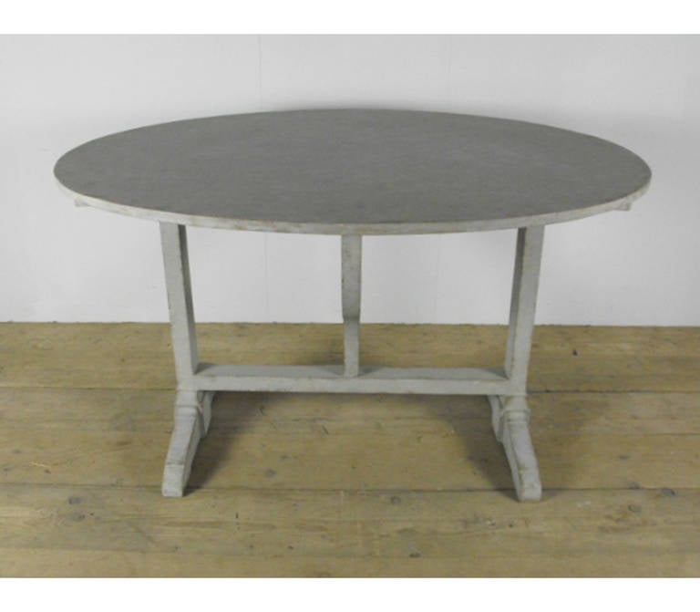 A lovely, oval 19th century French tilt-top wine table. This table with later refreshed paint was originally used in the vineyards for wine tasting. It would make a charming dining table.