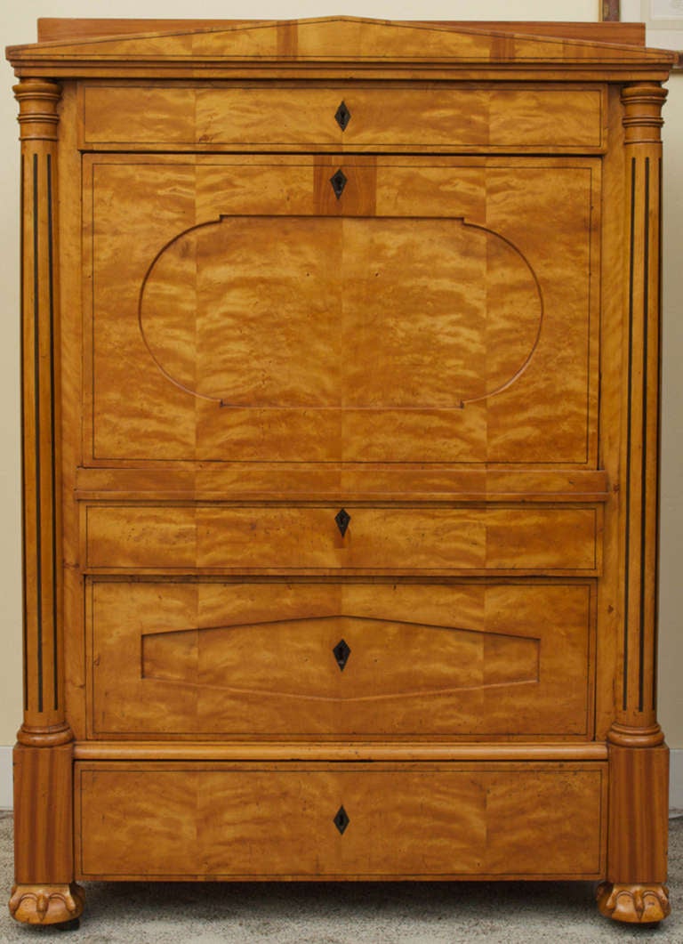 This rare, birch and satinwood Biedermeier secretaire makes a stunning architectural statement. There are three long drawers below the drop front writing surface with a long drawer above, all flanked by birch and ebonized columns. The drop front