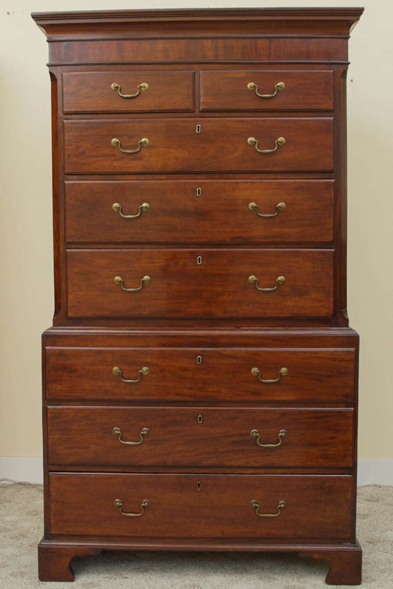 A stunning English, George III mahogany chest on chest with pine sides. The top section has two small drawers above three long drawers flanked by inlaid fluted corners. The two small top drawers have secret locks giving the impression that they are