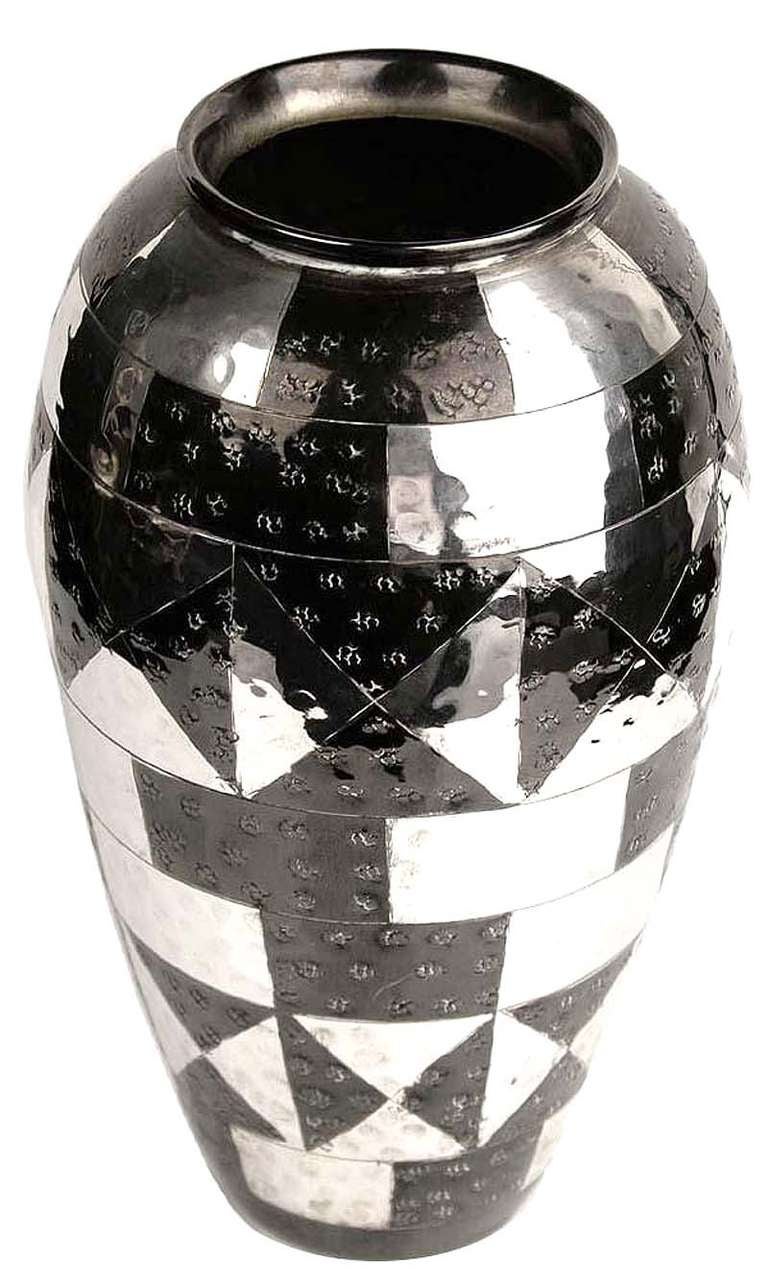 Versilberte Art Deco modernist  Vase, hergestellt um 1930 in Frankreich, nach Art von Christofle. Diese Vase zeigt Reihen von alternativen geometrischen Mustern, die patiniert wurden.  mit schwarzer Brünierung

.

Der Name des Art-Déco-Stils wurde
