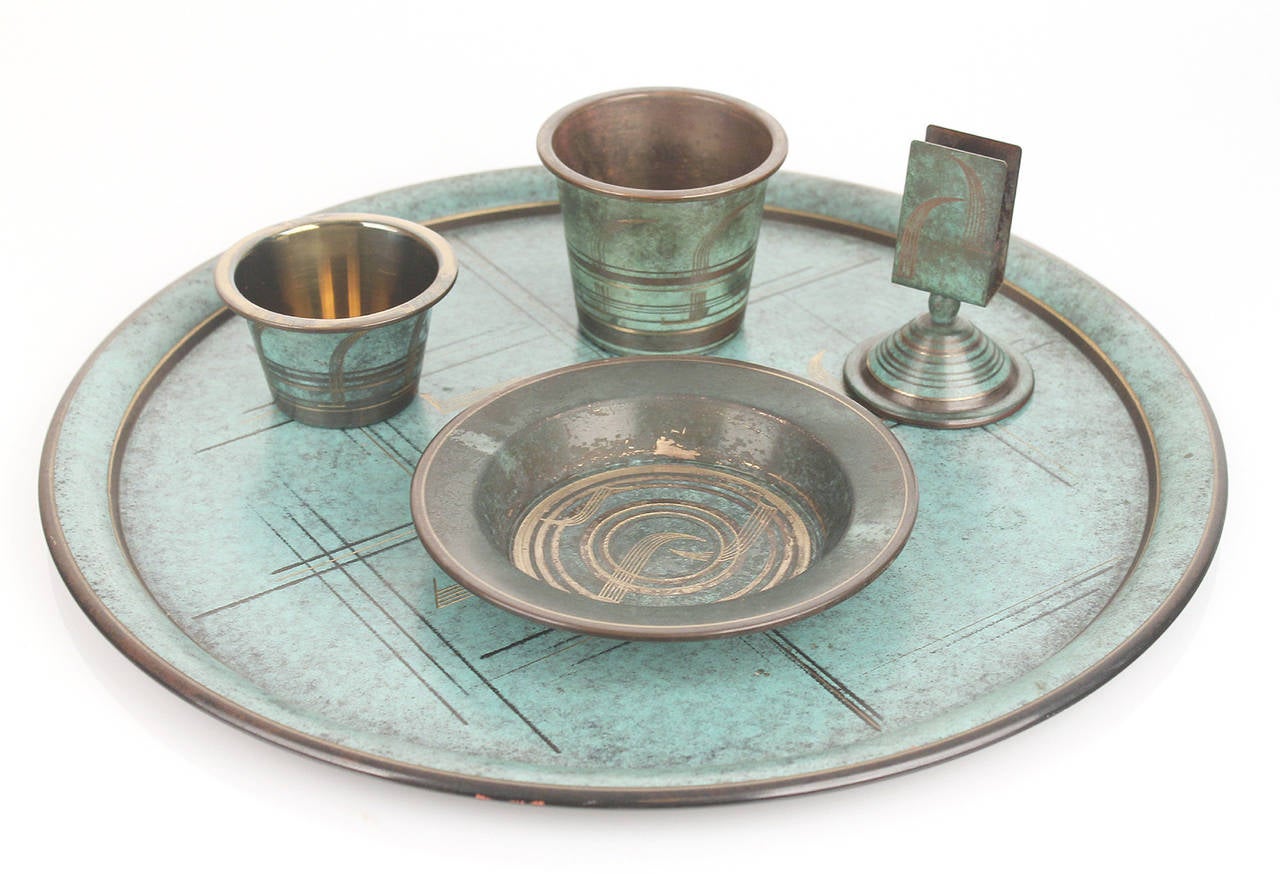 Very rare Art Deco Ikora accessory set with tray, by WMF, circa 1925-1930.

This set´s design and finish was directly inspired by the discovery
of Tuthankhamen´s tomb in 1923. The set is made out of brass and 
has a light to dark oxydized