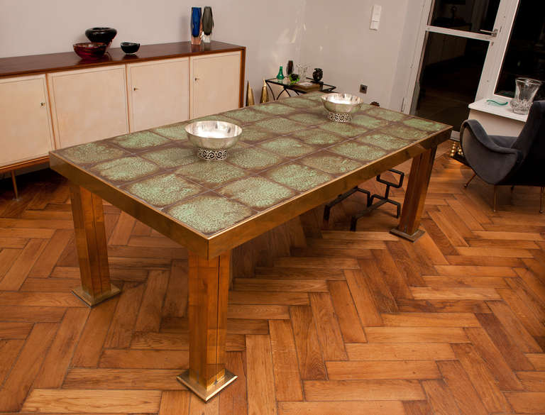 Amazing very solid dinning table, heavy massive brass legs, 32 ceramic plates in copper glaze, tabletops border also in massive brass. Below the table is a steel structure that holds the ceramic plates together. The table has a total weight of about