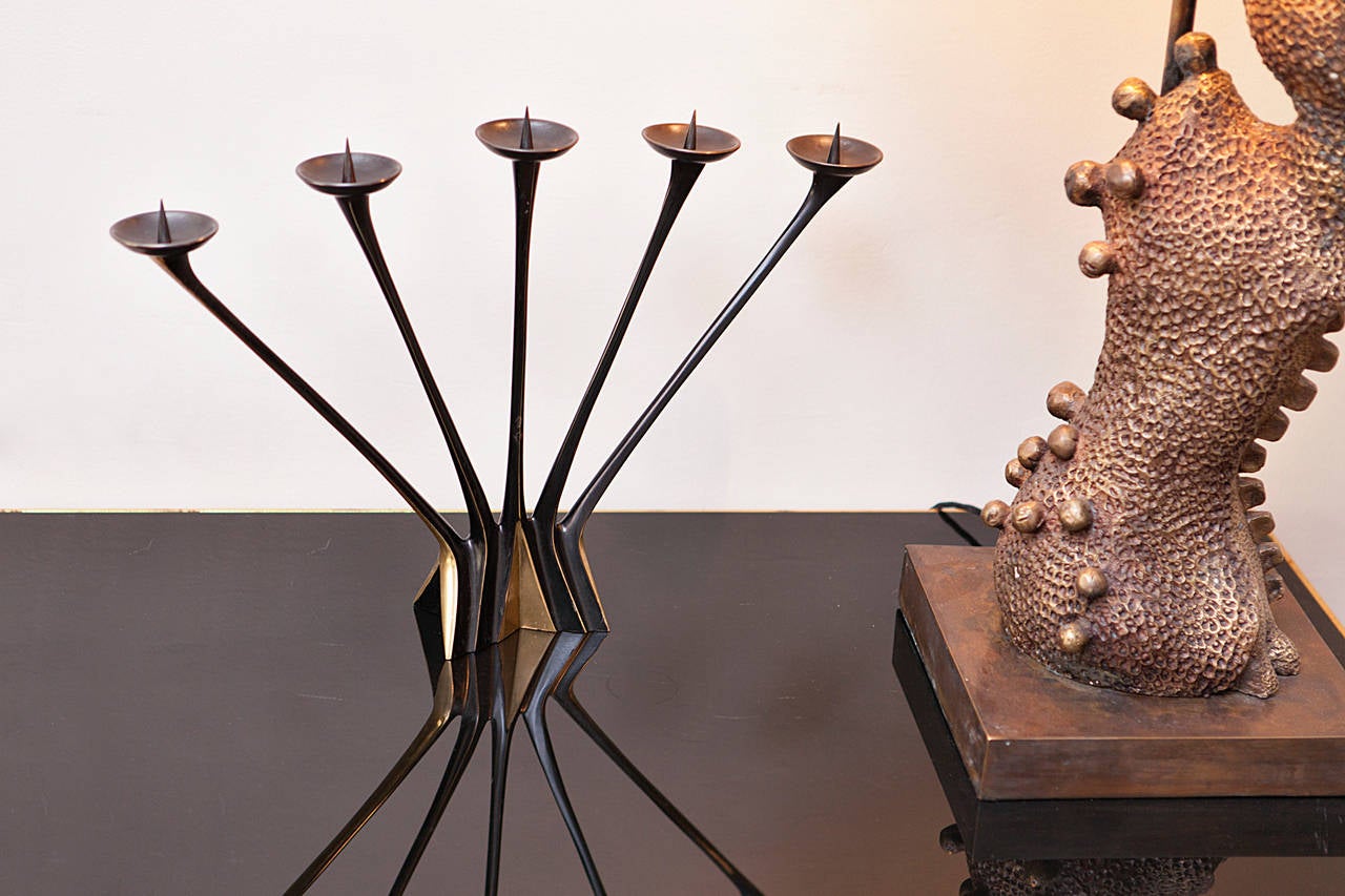 Elegant five candle large candlestick, attributed to Hagenauer, Vienna, circa 1950, brass and blackened brass, brass dishes, brass thorns, very heavy brass edition, height 34 cm, width 50 cm, depth 8 cm, diameter dishes 6 cm.
Very nice original