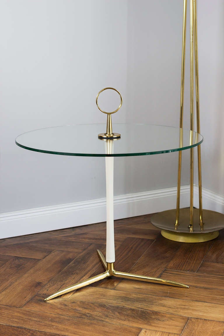 Cesare Lacca attributed Occasional side table, Italy, circa 1955. height 64 cm; diameter 60 cm. Brass, tubular steel painted white, glass top.
