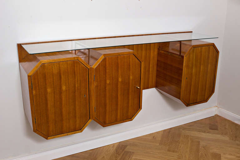Very elegant cubist wall or bar cabinet . Walnut, brass shelves, shelf with beveled glass. Italy, circa 1950. 68x180x43 cm