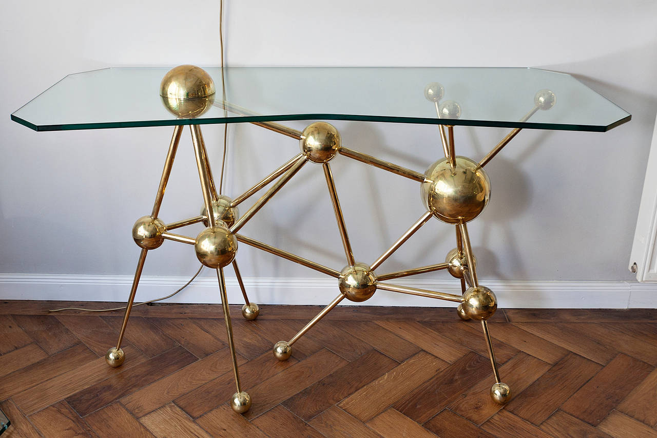 A very unusual console in the form of an atom design, France, circa 1970, very heavy brass balls, brass rods, asymmetrical very thick glass top. One brass ball fixed the glass top. Perfect handmade console in a very good condition!
Measures: Height