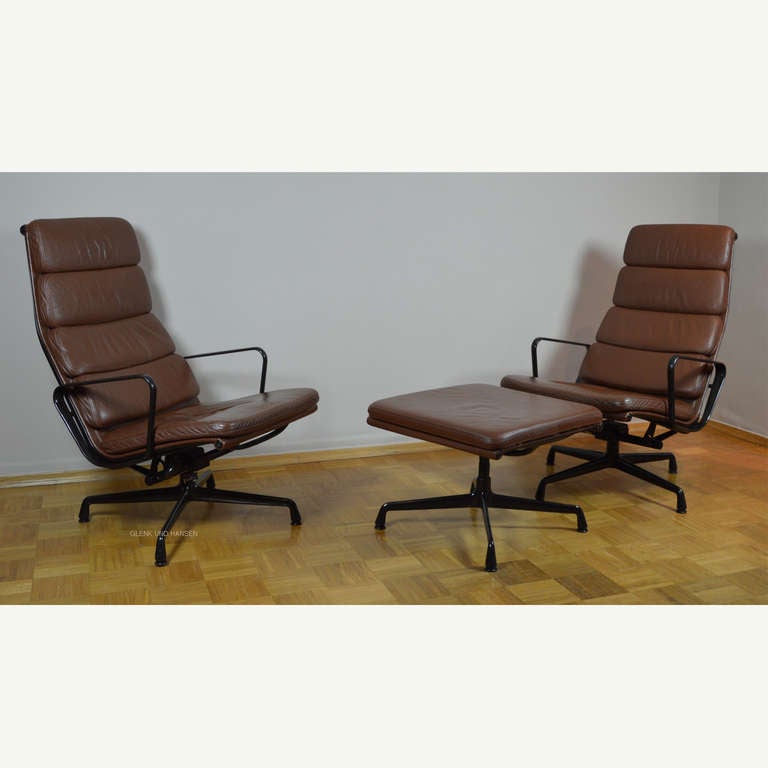 Designed by Ray and Charles Eames 
Produced by Vitra in 1985
High backrest with armrest. Swivel base at the two chairs. Base coated dark brown basic aluminium with adjustable tilt mechanism. Upholstered with stitched-on cushions in leather. Colour