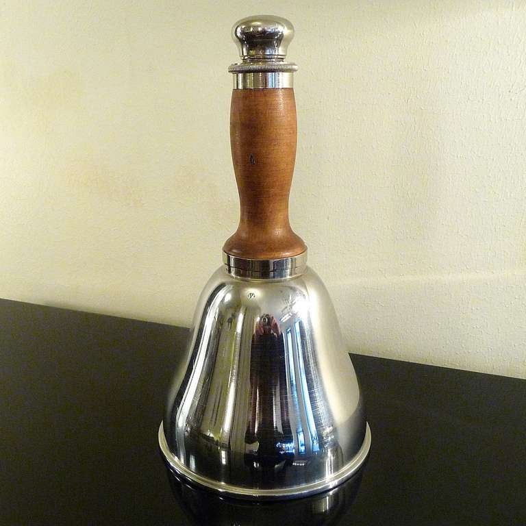 Left shaker:

A very rare hand-ringing bell shaped cocktail shaker, body in silver plated metal, wooden handle. Not marked.
Circa 1940

Dimensions: height 27 cm

Right shaker:
Rare cocktail and martini shaker by Gallia (Christofle).