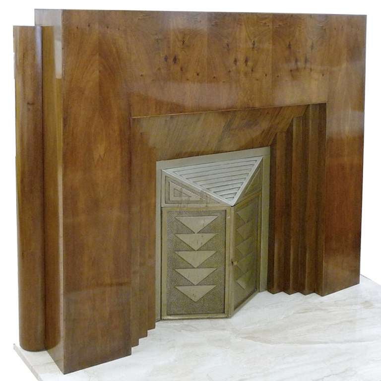 Modernist design from the 30s.
Hardwood corpus, with French walnut veneer.
Metal doors in relief, stamped and hammered geometric pattern. Marble top.

Dimensions:
Fireplace mantel - width 138cm, height 133.5 cm, depth 21cm.
Marble top - width