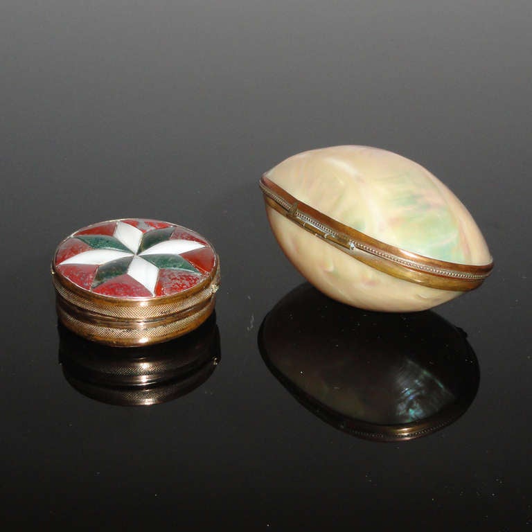 Exquisite oval shaped box made of genuine shell pearl, gilt brass mount.
Beginning 20th century.
Measures: Length 9 cm (3.54 in.).

Early Art Deco spectacular round box made in Pietra Dura (semi-precious hard stones inlay), with gilt brass