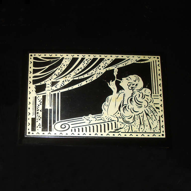 Black bakelite cigarette box designed in the typical Art Deco manner with a stylized silhouette of a Lady lightening up a cigarette.
Inside, on the lid reverse, moulded mark: 