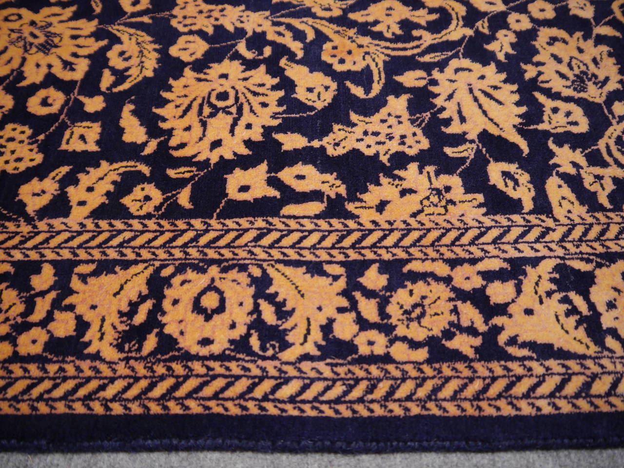 Hand-knotted in Srinagar with finest Cashmere wool and pure natural silk. Reduced color sheme with very dark blue woollen background and copper and dark orange pure silk design.
