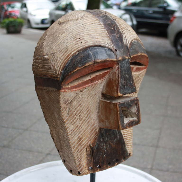 Kiwebe male mask from Eastern Songye, Zaire. A Kikashi type mask with engraved in wood with some light red painting around the eyes. Ca. 1960's.