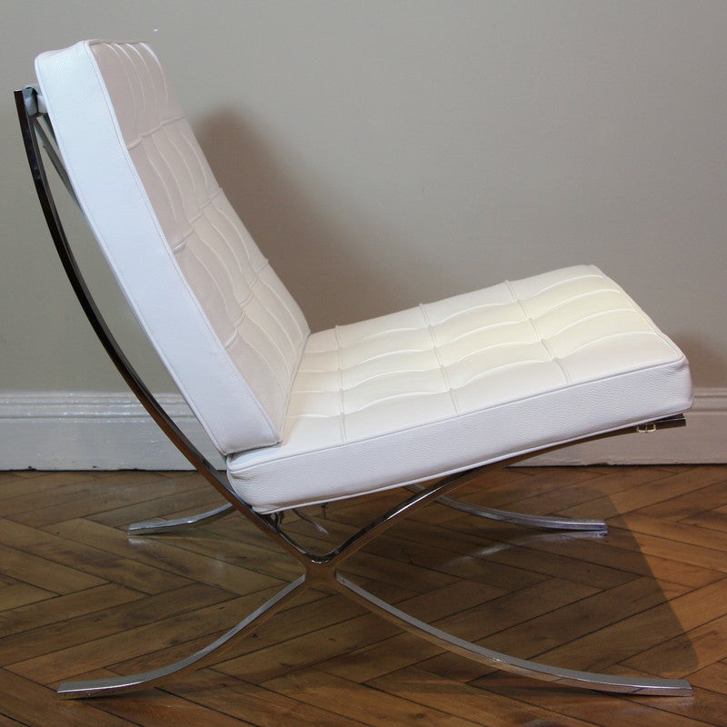 Cream colored, buttoned leather-upholstered cushions and bent chromed steel frame with leather straps. Ludwig Mies van der Rohe, in collaboration with Lilly Reich designed this lounge chair for the German Pavilion (1929 World Exhibition held in