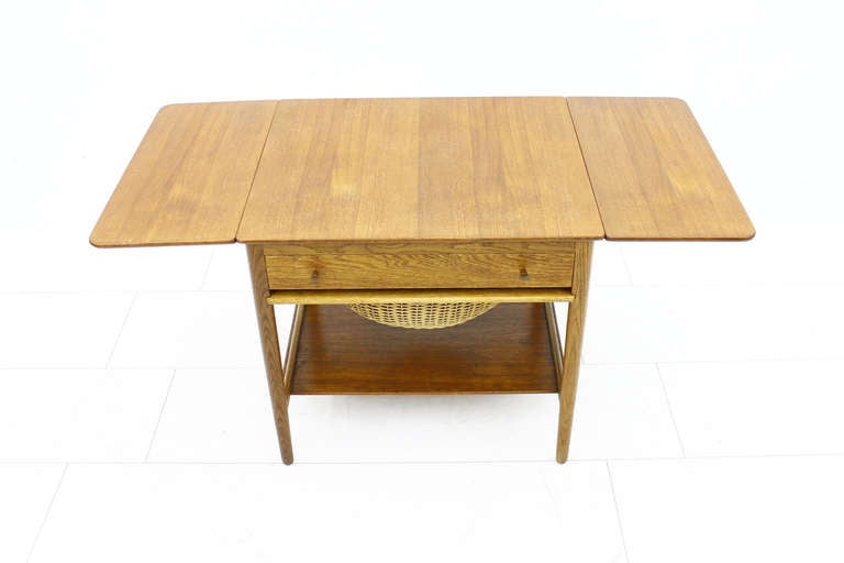 Sewing table by Hans J. Wegner. Teakwood, oak and wicker made by Andreas Tuck, Denmark. Good original condition!

Dimensions: H 60 cm, D 58 cm, W 67 cm + 2 x 27 cm.

Worldwide shipping.
