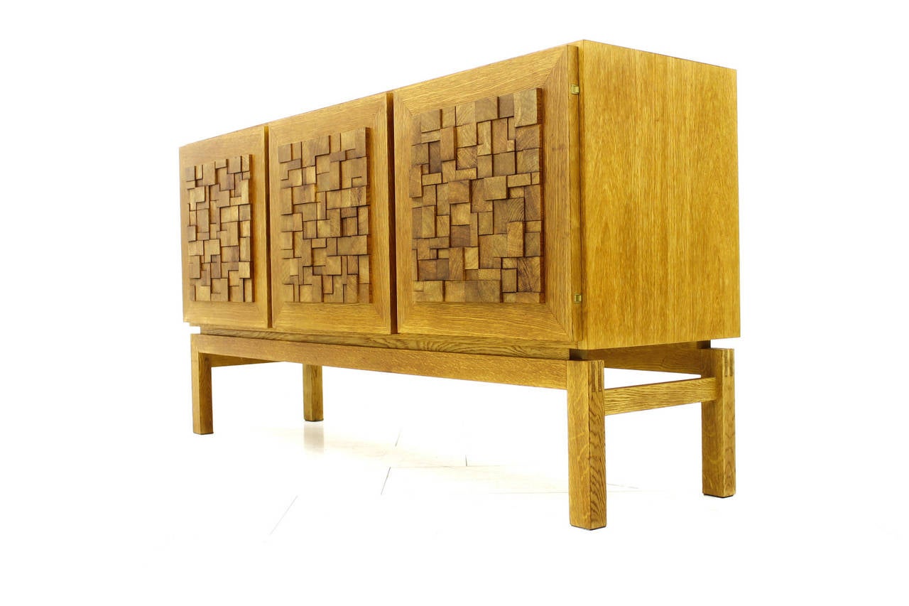 Beautiful Oak Sideboard with graphic Front, ca. 1970`s
Three Doors and three Drawers inside. Very good Condition and high Quality.

We offer worldwide shipping. Please contact us for a transport offer for a delivery to your door.