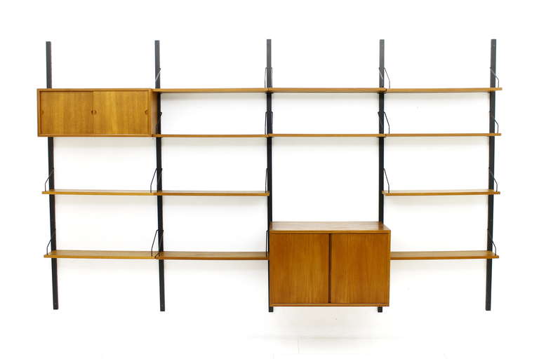 Large Teak Wood Shelf System by Poul Cadovius for Cado, ca. 1960`s with black painted Wall Holders.
5 x Wall Holder (196 cm)
1 x Cabinet with two Doors ( D 40 cm, H 51 cm, W 80 cm)
1 x Cabinet with two Sliding Doors, Wood ( D 24 cm, H33 cm, W 80