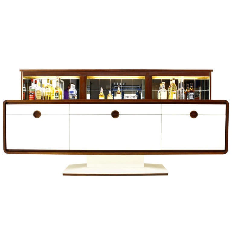 A Special Sideboard with an electric Bar and Mirror from the 70`s probably Germany. 
By pressing a button moves up from the rear part a illuminated mirror Bar.
The sides and the surface is veneered with rosewood. The Front and the Foot are coated