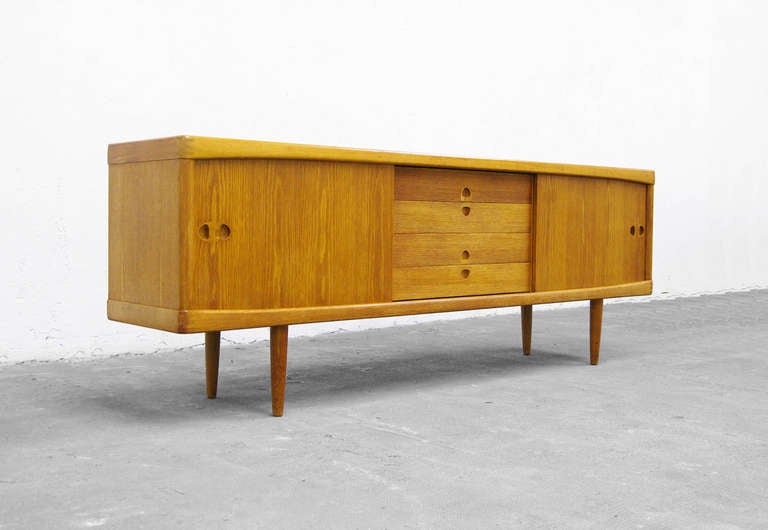 A stunning Oak wood credenza by H.W. Klein for Bramin.
The design is very organic, it´s an absolute show stopper.
The handles are beautifully hand carved and a real highlight to
the massive body of the piece.
Behind the two sliding doors, you´ll