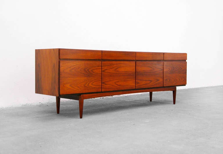 A striking rosewood sideboard by Ib Kofod-Larsen for Faarup.
This is some of Kofod-Larsen´s most impressive piece Modell FA-66.
We love the pure and classic design.
It has four doors, behind there are two levels and 5 drawers for cutlery.
There