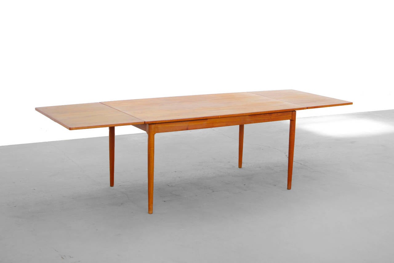 This gorgeous and sleek teak dining table is attributed by Harry Ostergaard. 
The piece is extendable and thus offers seating for up to 10 people. 
This would make the perfect centerpiece for your modern environment.