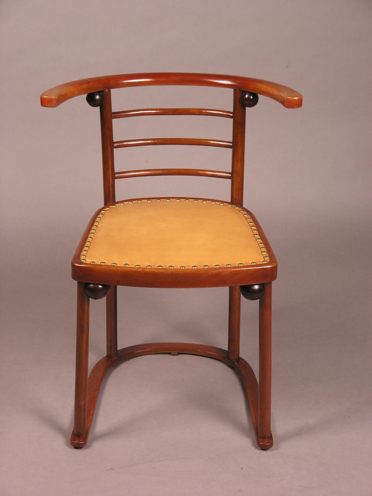 This chair was published as part of the set No. 728 in the Bentwood Sales Catalogue of Jacob & Josef Kohn in 1906. Its basic form is the horseshoe, which is present in its base and in the back and arm rests. Four straight rods connect these two