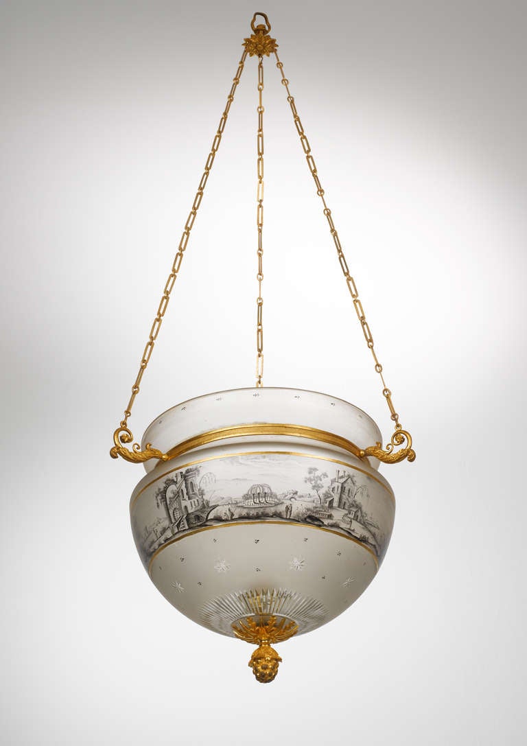 Die urnförmige Glasschale ist mit einer vergoldeten Bronzeaufhängung versehen und hat einen Kerzenhalter im Inneren. Der gesamte Korpus ist in Schwarzlot und Gold mit einer durchgehenden Landschaftsszene mit architektonischen Elementen und Figuren
