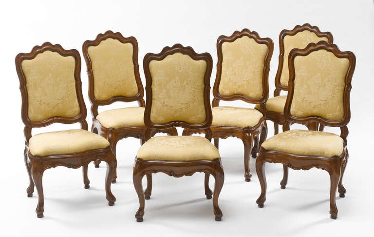 Each with moulded cartouche-shaped padded back and seat covered in monochrome chinoiserie silk, the wavy seat rail with foliage, on cabriole legs and scroll feet.