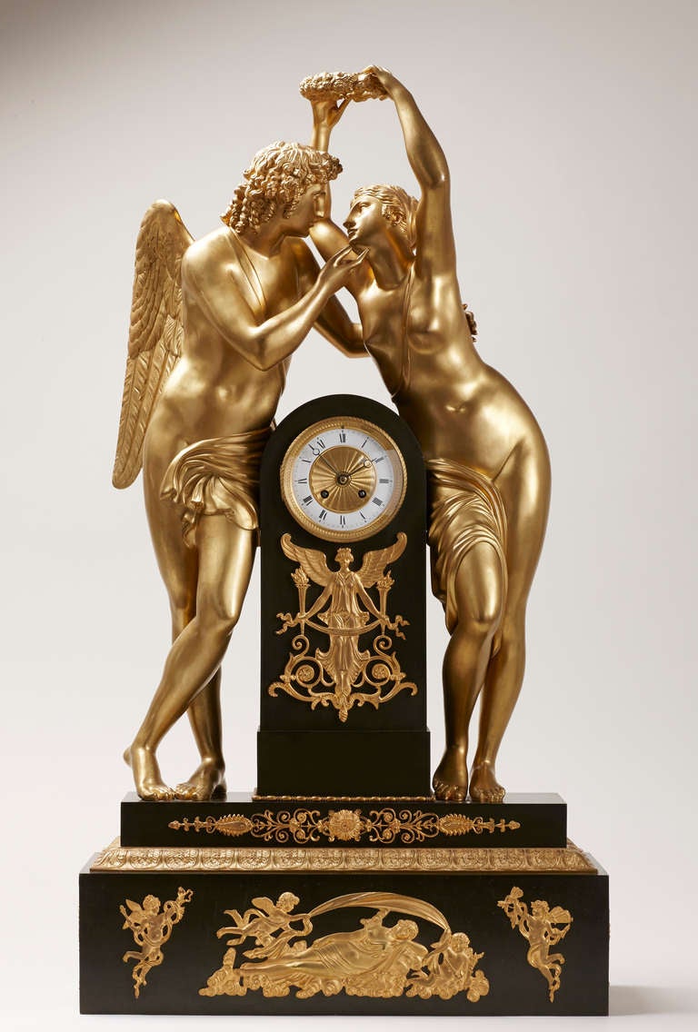 A large and very impressive Empire gilt and dark green patinated bronze figural mantel clock, after an Empire design by Claude Michallon (1751-1799). The model was first delivered on the 1st of February 1812 by Feuchère to the Palais deTuileries as