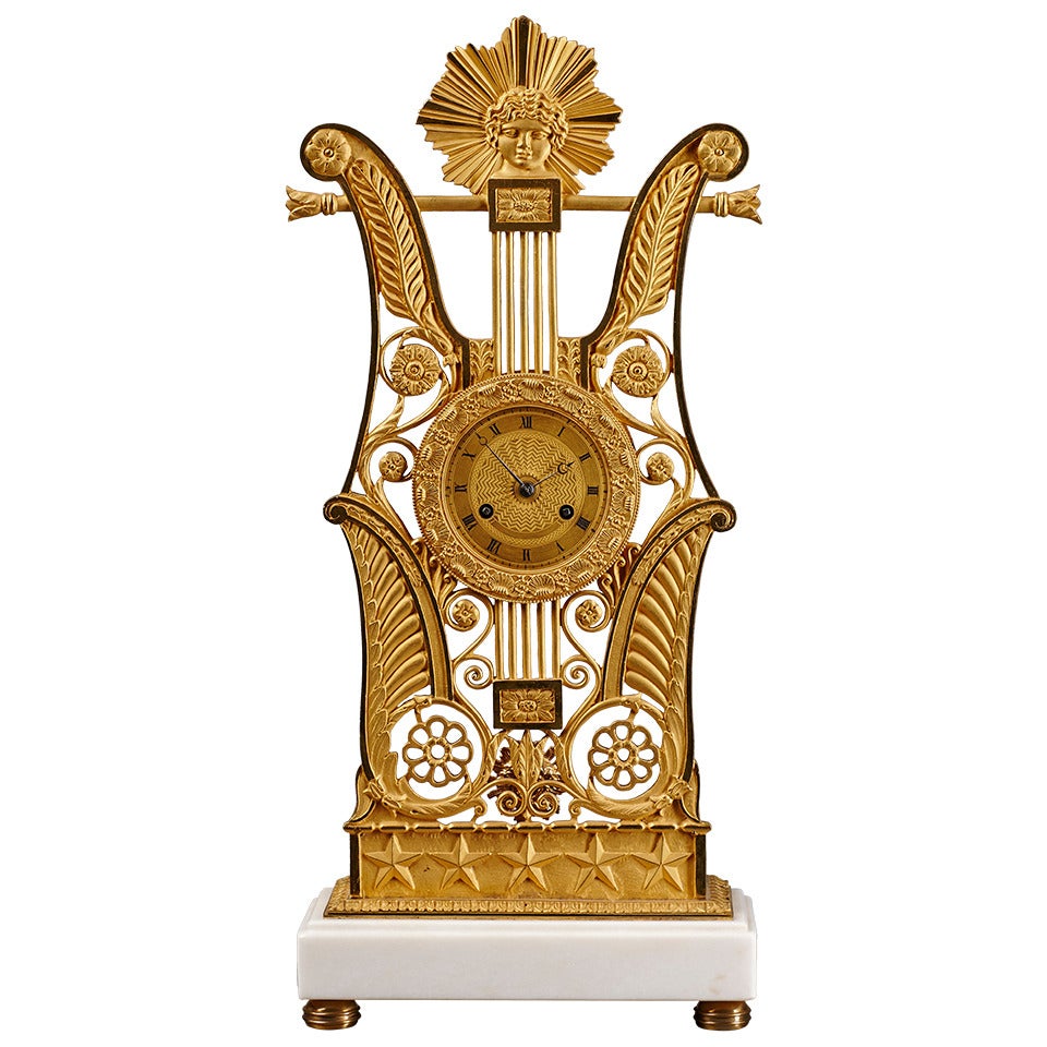 Pendule de cheminée en forme de lyre en bronze doré de la période de la restauration française avec masque d'Apollon