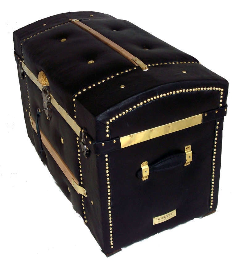 Medium sized American made antique curve-top recovered in supple black leather, with padded middle sections.  This piece has all original hardware including its' working Eagle lock and key, with an added solid brass lid lift and hand-made solid